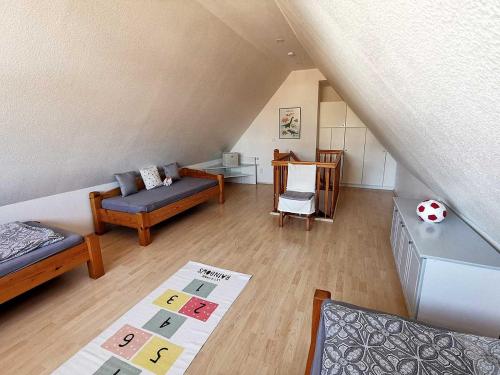 a attic room with a bed and a couch at Haus Wyden in Utersum