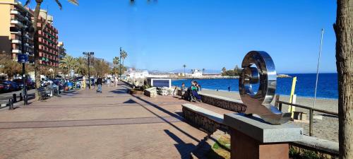 a sidewalk next to the beach with a large sculpture at Apartamento Cervantes in Fuengirola