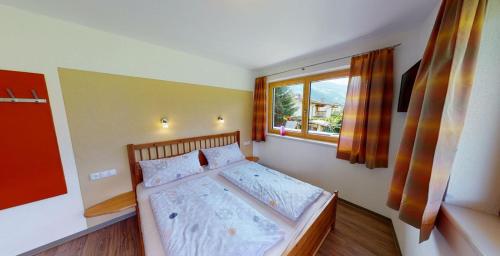 Schlafzimmer mit einem großen Bett und einem Fenster in der Unterkunft Ferienwohnung Thanner in Stumm