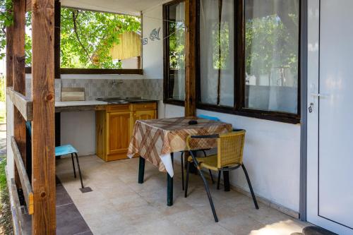 a kitchen with a table and chairs in a room at Bungalow Silitur in Ahtopol