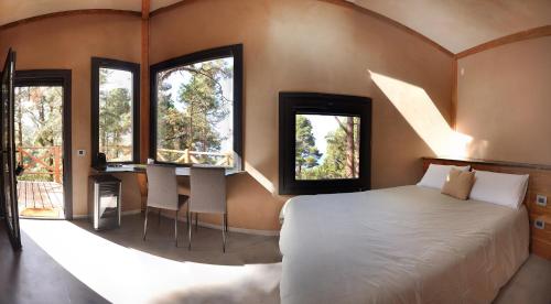 sypialnia z łóżkiem, 2 oknami i biurkiem w obiekcie Casita colgada "Can Lia" w mieście La Guancha