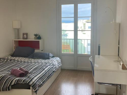 une chambre avec un lit et une grande fenêtre dans l'établissement Tortue de Mer, à Antibes