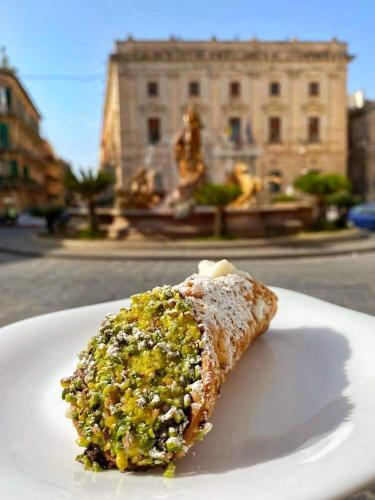 un pezzo di cibo su un piatto bianco di B&B Ortigia Bedda a Siracusa