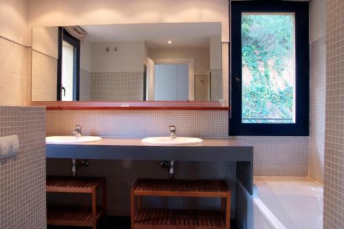 a bathroom with two sinks and a large mirror at VISTA MAR - MEGIN in Tamariu