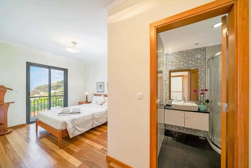 a bedroom with a bed and a bathroom with a mirror at Boavista in Calheta