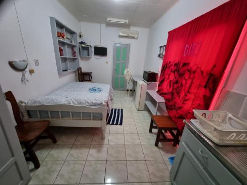a bedroom with a bed and a red curtain at Kwarts Appartementen in Paramaribo