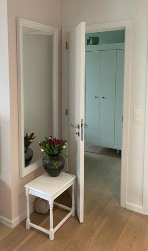 a room with a vase on a table and a mirror at "VH apartment" - center of Antwerp - free parking in Antwerp
