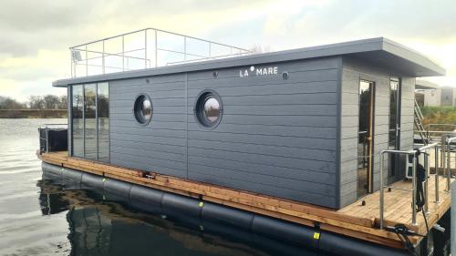 a tiny house on a dock on the water at Hausboot La Mare Emma in Weyhe