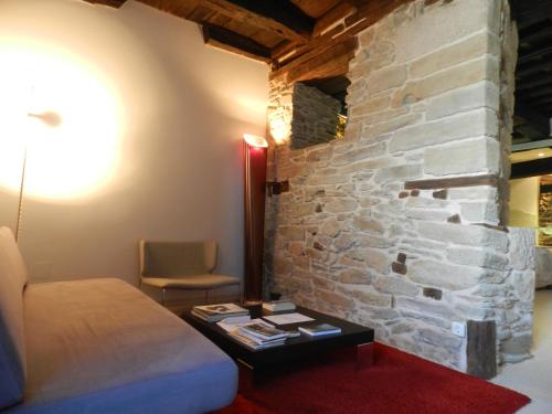 a room with a bed and a stone wall at Posada Real La Pascasia in Puebla de Sanabria