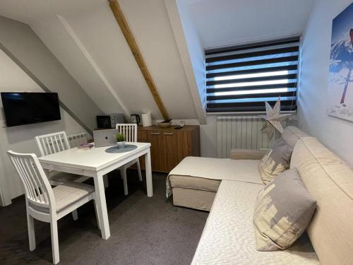 a small living room with a couch and a table at Planinski vrhovi Jelač in Kopaonik