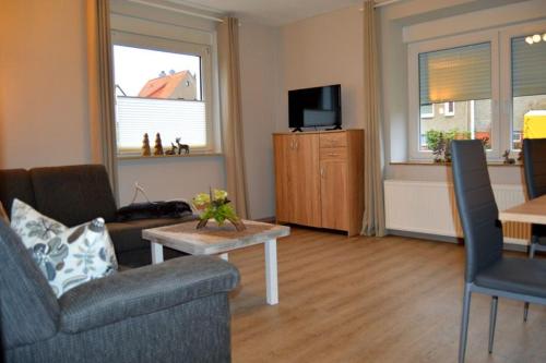 a living room with a couch and a table and a tv at C. Wulf Gästezimmer in Bückeburg