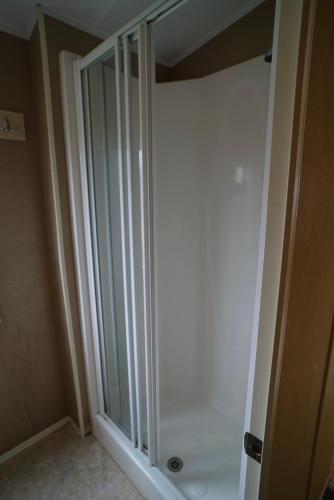 a shower stall in a bathroom with a glass door at Cozy Hunstanton caravan sleeps 8 pets go free in Hunstanton