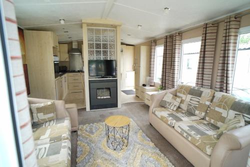 a living room with a couch and a table at Cozy Hunstanton caravan sleeps 8 pets go free in Hunstanton