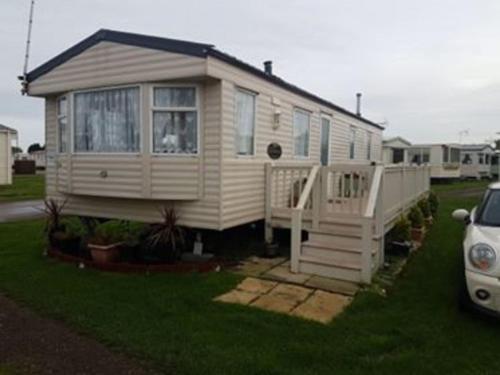 a tiny house sitting on top of a yard at pets stay free 3 bedroom caravan at heacham beach in Heacham