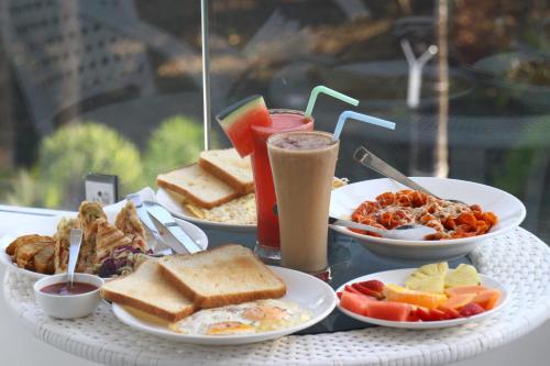 a table topped with plates of breakfast foods and drinks at La Vera Boutique Hotel, Mandrem in Mandrem