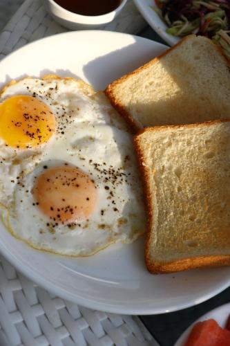 two eggs and two slices of bread on a white plate at La Vera Boutique Hotel, Mandrem in Mandrem