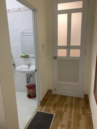 a bathroom with a door leading to a sink at MOON Home in Vung Tau