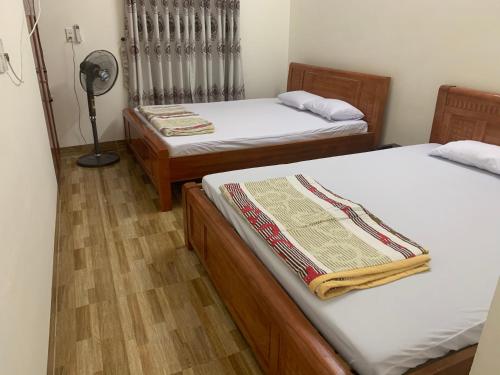 a room with two beds and a fan at MOON Home in Vung Tau