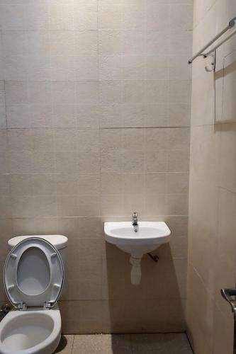 La salle de bains est pourvue de toilettes et d'un lavabo. dans l'établissement RedDoorz near Simpang Tujuh Kudus, à Kudus