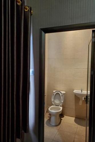 La salle de bains est pourvue de toilettes et d'un lavabo. dans l'établissement RedDoorz near Simpang Tujuh Kudus, à Kudus