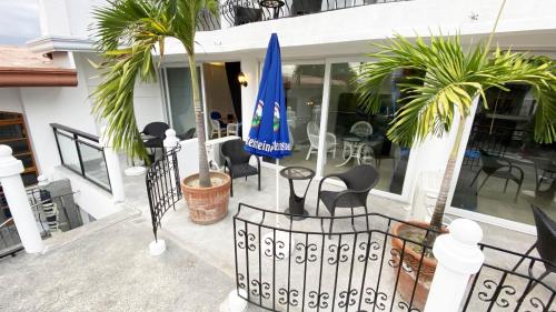 a porch with chairs and a blue umbrella at Clarkton Hotel Apartment in Angeles