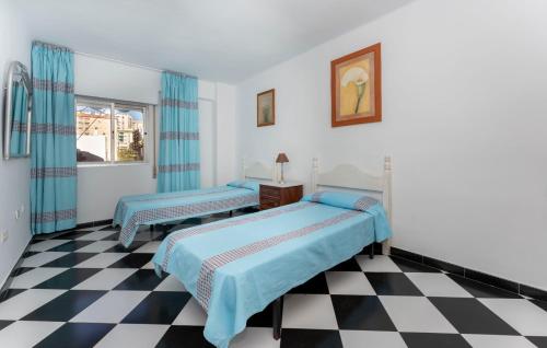 1 dormitorio con 2 camas y suelo a cuadros en Malaga downtown and beach apartment, en Málaga