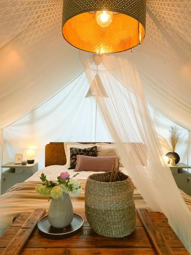 a bedroom with a bed with two vases on a table at Vintage tent at the Lovsin Estate in Metlika