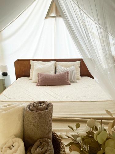 a bed with a canopy with pillows and towels on it at Vintage tent at the Lovsin Estate in Metlika