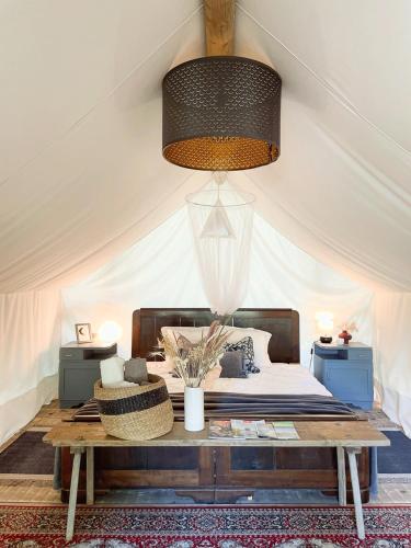 a bedroom with a bed in a tent with a table at Vintage tent at the Lovsin Estate in Metlika