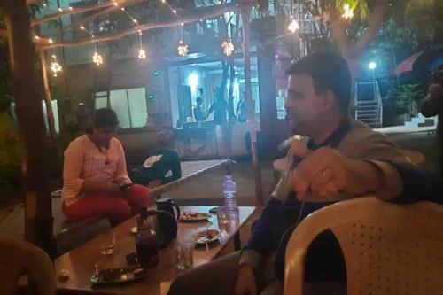a man and a woman sitting at a table in a restaurant at RS Farms in Vasind