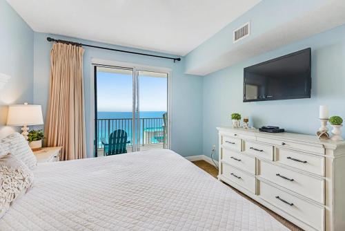 a bedroom with a bed with a television and a balcony at Ariel Dunes I 2207 in Destin