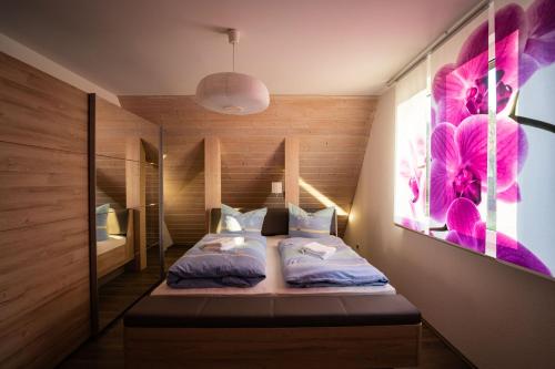 a bedroom with two beds and a painting on the wall at Ferienhaus Thüringer Wald - Garten & Terrasse in Bischofrod