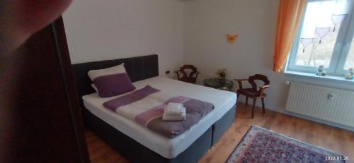 a bedroom with a bed with purple pillows and a window at Apartment O2 - Gehobene 4-Zimmer Wohnung 145qm für 1-6 Personen 2x DZ 1x ZZ in Gravenwerth