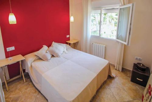 モライラにあるEl Pinarの赤い壁のベッドルーム1室(大型ベッド1台付)