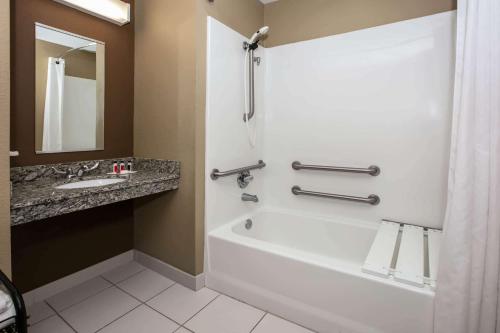 y baño con bañera blanca y lavamanos. en Microtel Inn and Suites Pecos, en Pecos