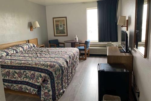 een hotelkamer met een bed en een tafel bij Travelodge by Wyndham Green River UT in Green River
