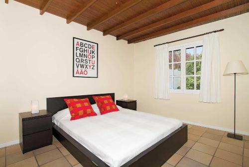プエルト・デル・カルメンにあるMiguelのベッドルーム1室(赤い枕のベッド1台、窓付)