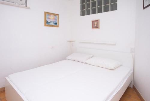 a white bed in a room with white walls at N91 - Numana, nuova taverna bilocale in Numana