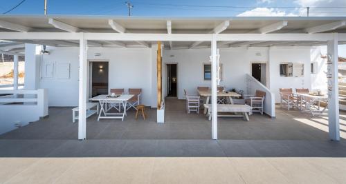 a room with white walls and tables and chairs at Anemi Suites in Adamas