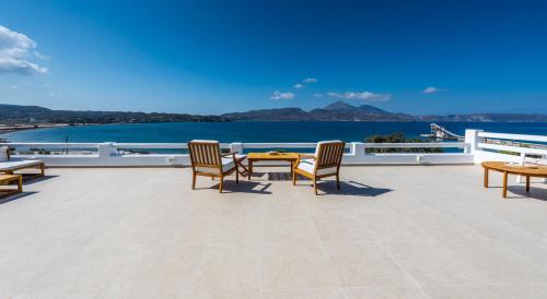 a patio with a table and chairs and the water at Anemi Suites in Adamas
