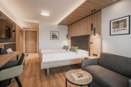 um quarto de hotel com uma cama e um sofá em FIRSTpeak Zauchensee em Zauchensee