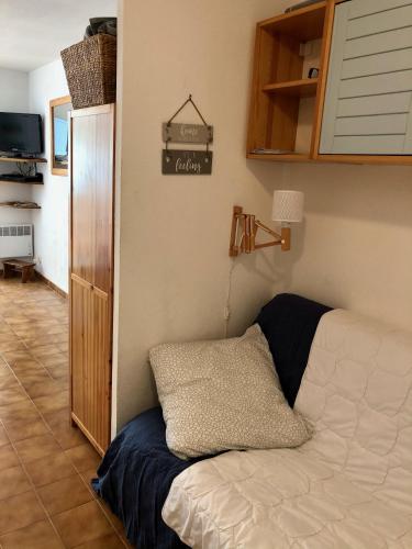 Cette chambre comprend un lit et une armoire avec un oreiller. dans l'établissement Studio Sausset Madura, à Sausset-les-Pins