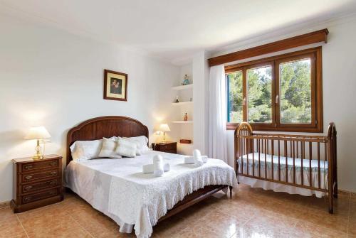 アルクーディアにあるManresaのベッドルーム1室(ベッド1台、ベビーベッド1台、窓付)