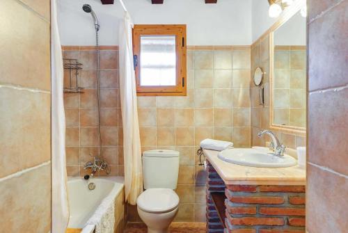 a bathroom with a toilet and a sink and a tub at Urdiales in Frigiliana