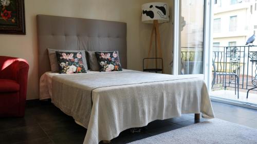 - une chambre avec un lit doté d'une couverture blanche et d'une fenêtre dans l'établissement Cozy studio with a sea view, à Nice