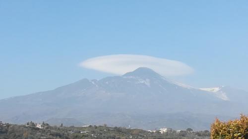 a helicopter flies over a mountain in the sky at B&B Il Vulcano in Aci Catena
