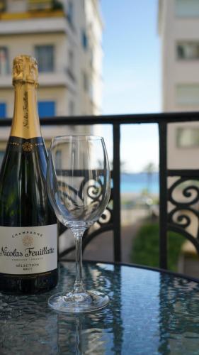 - une bouteille de champagne et un verre de vin sur une table dans l'établissement Cozy studio with a sea view, à Nice