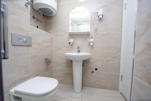 a bathroom with a white toilet and a sink at Apartment Sofija in Budva