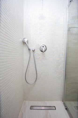 a shower in a white tiled bathroom at Apartment Sofija in Budva