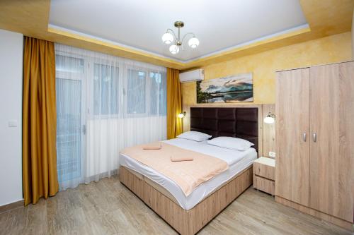 a bedroom with a large bed and a large window at Apartment Sofija in Budva